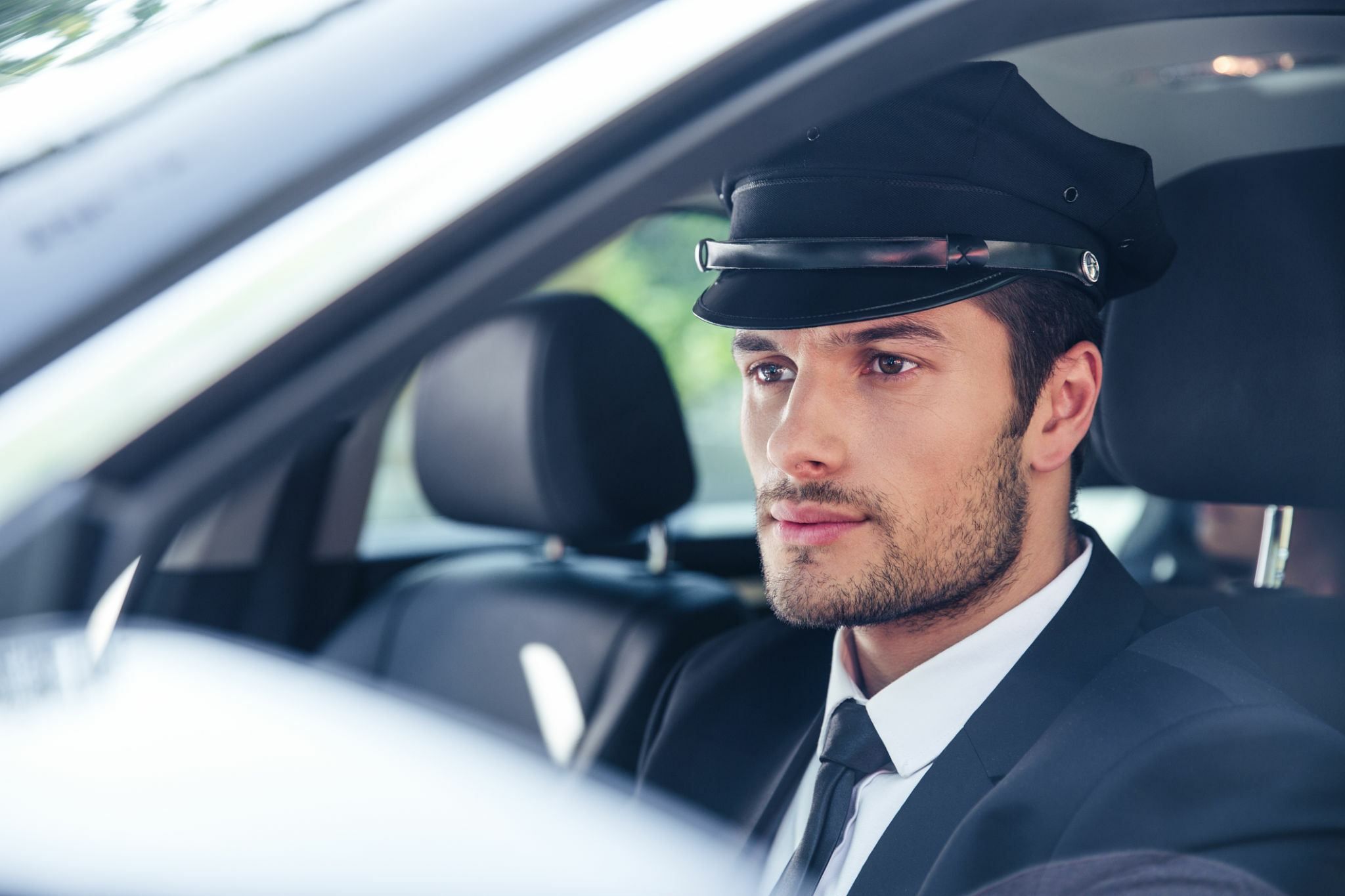 Portrait of a handsome male chauffeur sitting in a car